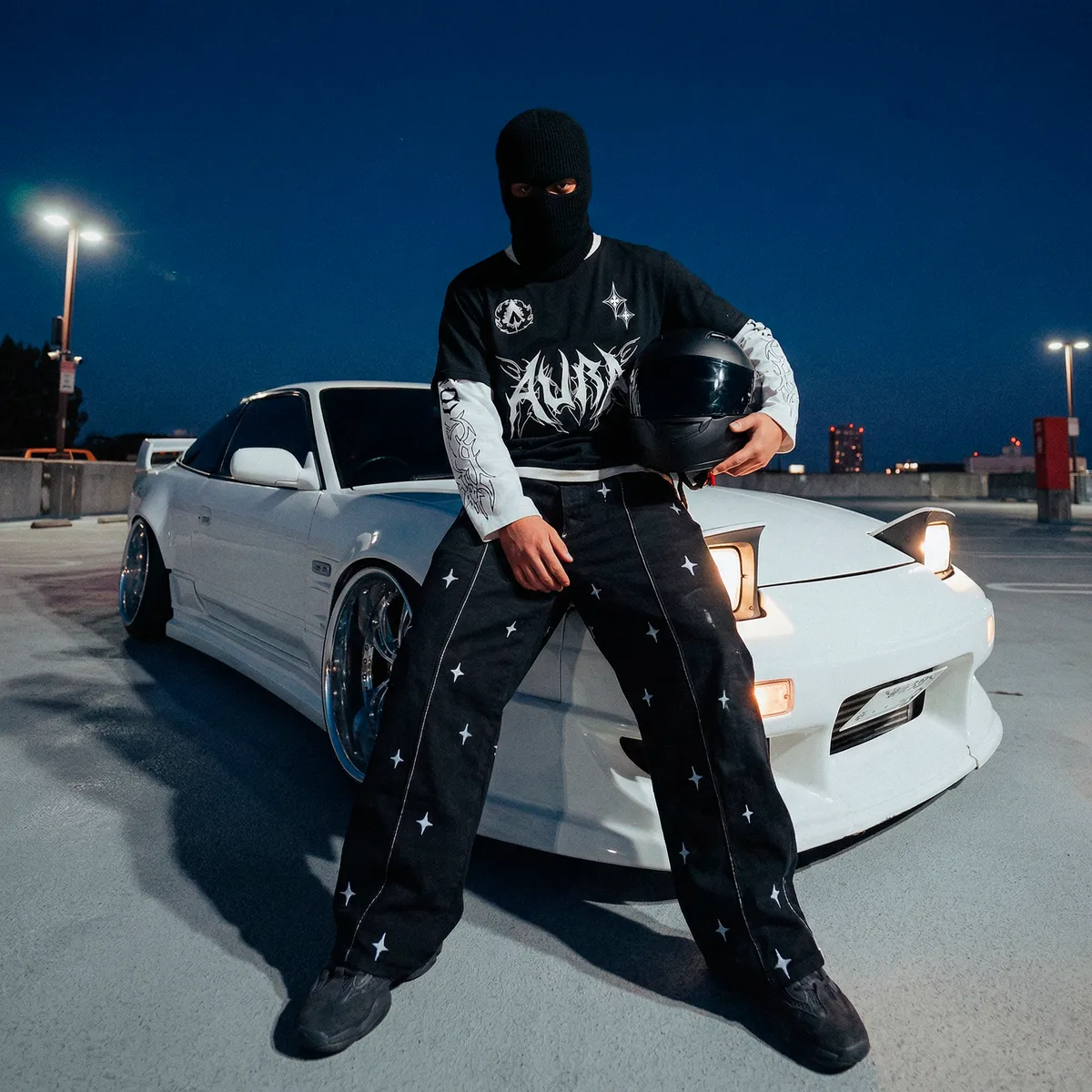 Campaña de moda nocturna con IA para la marca AURA: modelo con pasamontañas junto a un coche deportivo blanco
